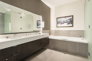 Ensuite main bathroom with double vanity, white quartz countertops and deep soaker tub