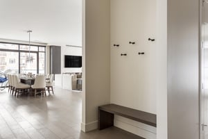 Lift 601 entryway with wall hooks and wooden bench opening to the dining and living room
