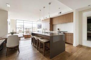 Chefs kitchen with dark quartz kitchen island and bar seating for 3 in leather and wood bar stools
