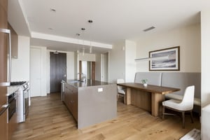 Kitchen and dining area, dark quartz kitchen island opens to the solid wood dining room table and dining nook