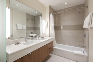 Full ensuite guest bathroom, quartz countertops and tiled showertub, dual vanity