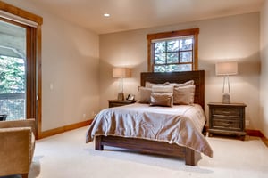 Comfortable king bed in the first guest bedroom with sliding glass door for access to private patio