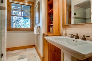 Full guest bath, slatestone tiled floor, and large picture window