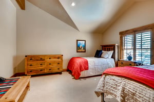 Versatile twin beds and trundle in the final guest bedroom with wooden chest of drawers