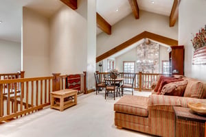 Upper level lounge area looks over the stunning iron chandelier in the living room