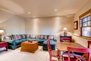 Large sectional in the game room, wooden card table with seating for 4