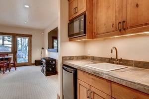 Game room large screen TV, wet bar with slatestone tiling, mini fridge and microwave