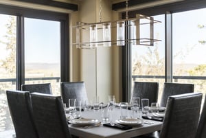 Dining table with ski resort views and glass linear chandelier