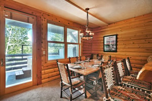 Pine wood interior, rustic log seating in the dining room and bar chairs at the kitchen island