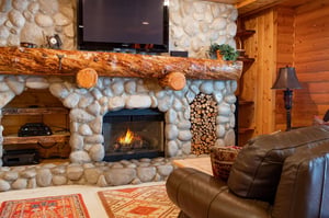 Log mantle over stone fireplace