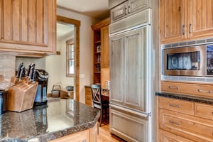 Fully equipped kitchen with French door wood paneled refrigerator and studywork nook in the entryway