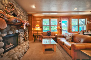 Bright picture windows line the western wall of the condo, two cozy couches in the living room