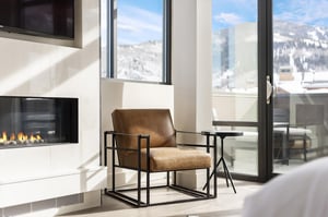 Main bedroom suite with leather accent chair aside the gas fireplace