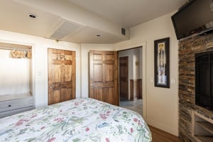Bedroom with inroom fireplace, flat screen TV and dark wooden doors