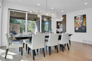 Vacation rental dining area surrounded by large windows and a table setting for 10 guests.