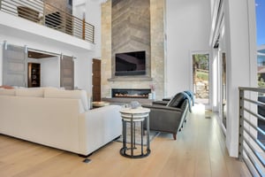 Vacation rental living room with a floor to ceiling tiled fireplace and flat screen TV.