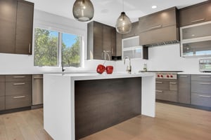 The vacation rental kitchen with a large window over the sink looking out to the oak grove.