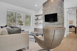 Vacation rental second living room with leather club chair, stone hearth, and TV.