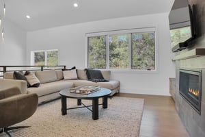 Vacation rental second living room with light grey sectional sofa and views of the surrounding hillside of oak trees.
