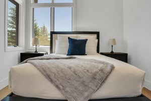 Vacation rental bedroom with queen size bed with crisp white linens, minky throw blanket, and blue accent pillow.