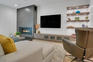 Vacation rental game room with flat screen TV, gas fireplace, and built in wooden shelves.