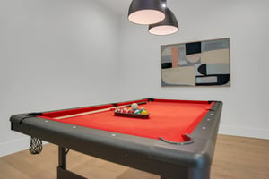 Vacation rental with pool table and modern art on the walls.