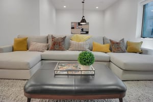 Vacation rental cream colored sofa and leather ottoman in the game room.