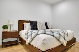 Vacation rental bedroom with a king size bed with a wooden bedframe and wooden end tables.