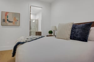 Vacation rental bedroom with a en suite bathroom attached and modern art on the walls.