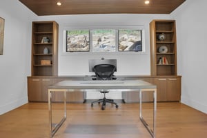 Vacation rental office with modern desk and built in wooden cabinets with built in desk.