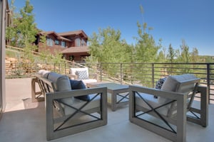 Vacation rental spacious deck with seating for six on light colored and comfortable patio furniture.