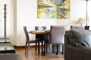 Dining table with armless high back leather chairs and aspen tree art