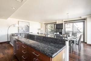 Kitchen island with dark gray granite countertops and bar seating for 3