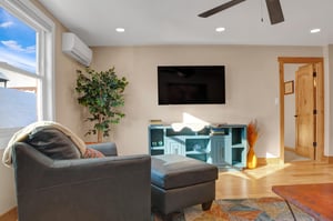 Large screen smart TV in the living room and blue leather armchair and ottoman