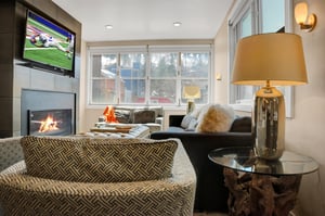 Rio Grande 202s living room with gas burning fireplace, flat screen TV, and views of the snowy mountains and colorful homes.
