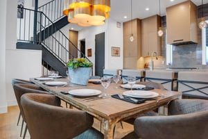Seating for 8 at the dining room table with modern barrel dining chairs and a unique modern gold chandelier.