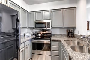 Snow Flower 12s kitchen has light grey cabinetry, stainless steel appliances and crisp white walls.