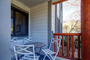 Snow Flower 12s deck with wooden railing, small round table and 4 chairs.
