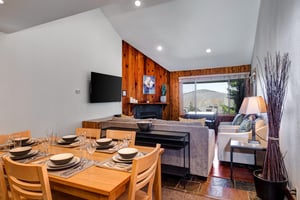 Snow Flower 29s open concept dining area and living area with vaulted ceilings, recessed lighting and white and wood walls.