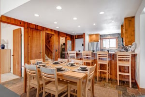 Snow Flower 29s open concept dining area and kitchen with dropped ceiling, recessed lighting and wood paneled wall.