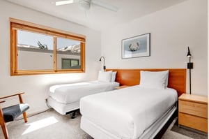 Bedroom 4 has 2 twin beds, wood headboard with 2 attached lights, shared night stand and polar bear picture.