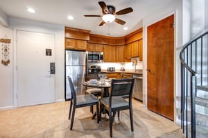 Snow Flower 31s dining area situated in the center of the kitchen with seating and place settings for 4 guests.