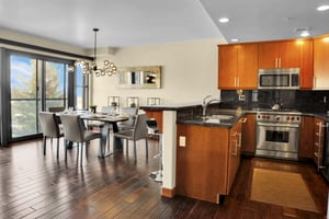 Lowell 304s open concept kitchen and dining area with hard wood floors throughout, creamy walls and mirror on the wall.