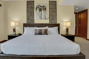 Lowell 304s main suite with king size bed, two nights stands with lamps and horse painting above the bed.