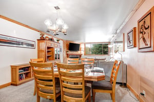 Snow Flower 43s dining area has a wood table with seating for 6 on wood chairs and has place settings for 6.