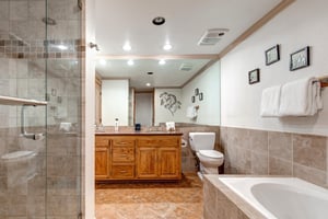 Snow Flower 43s en suite bathroom has a medium toned wood double sink vanity, two sinks, large mirror and recessed lighting.