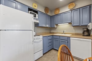 Snow Flower 72s kitchen with blue cabinets and white appliances.