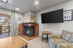 Snow Flower 72s living room with fireplace, flat screen TV, and griege walls.