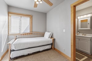 Snow Flower 72s bedroom with a twin bed with twin trundle, white sheets and pillows, greige walls and blonde wood accents.