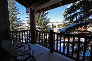 Snow Flower 72s covered patio with evergreen trees surrounding it and blue sky peaking out.